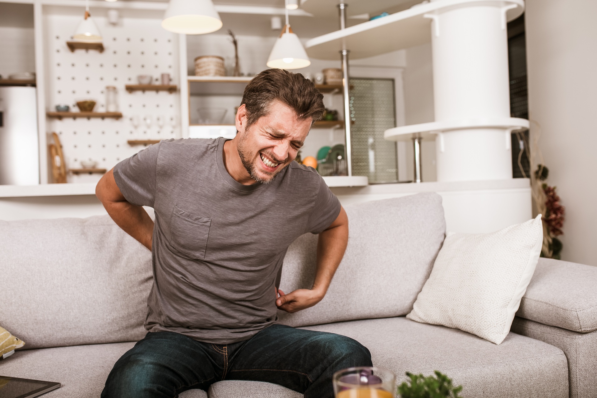 Mann haelt sich mit Schmerzen den Rücken | betriebliche Gesundheitsförderung